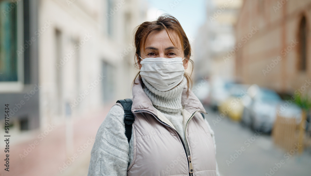 Middle age hispanic woman wearing medical mask at street Middle age hispanic woman wearing medical mask at street
