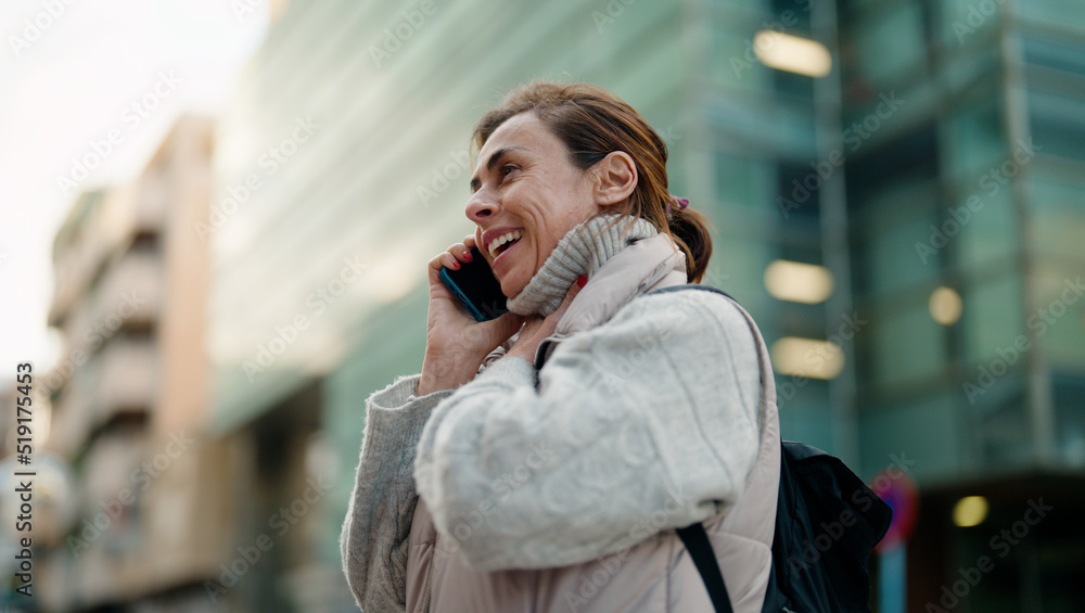 Fototapeta premium Middle age hispanic woman smiling confident talking on the smartphone at street