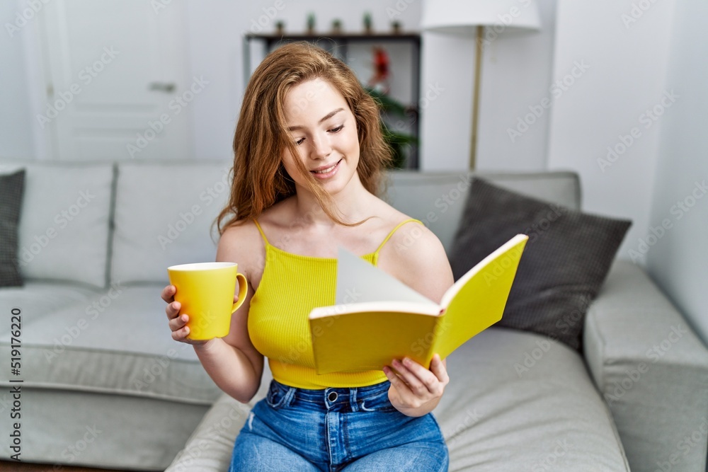 Young redhead girl reading book drinking coffee at home Young redhead girl reading book drinking coffee at home
