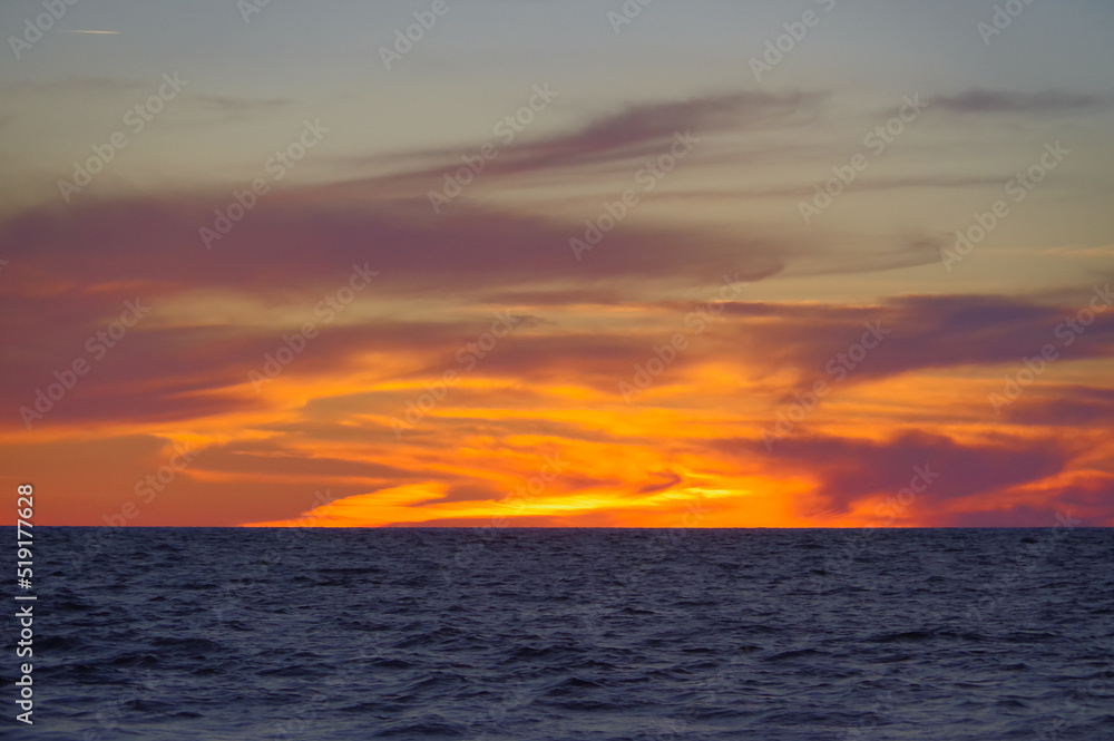 Colorful orange sunset over Baltic sea on clear summer day
