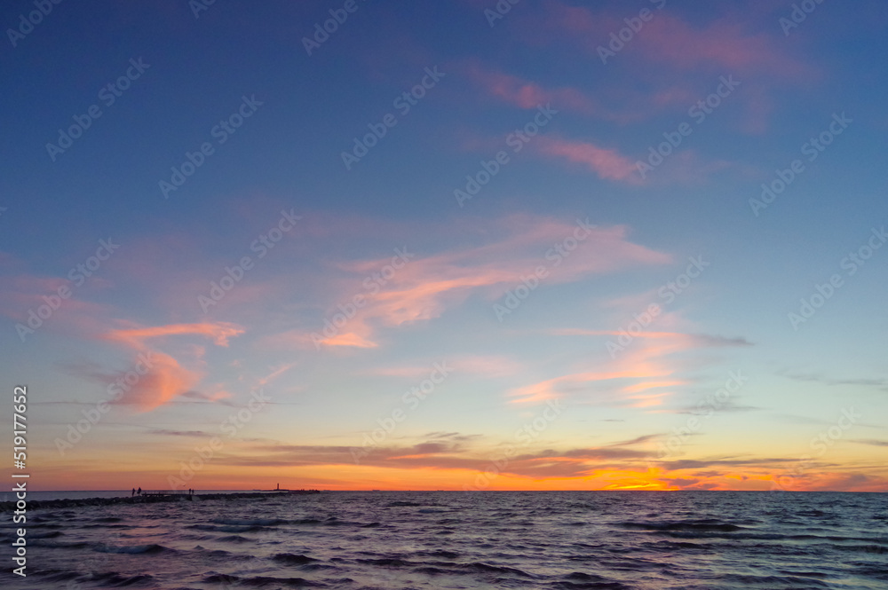 Colorful orange sunset over Baltic sea on clear summer day
