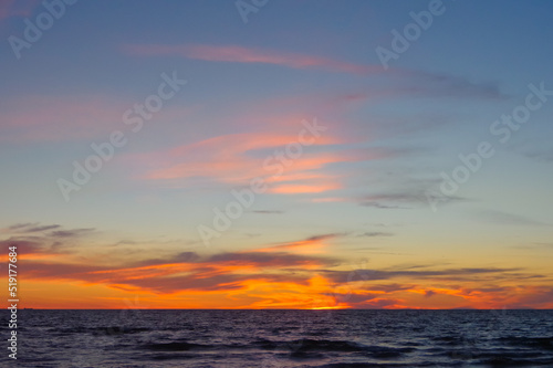 Colorful orange sunset over Baltic sea on clear summer day