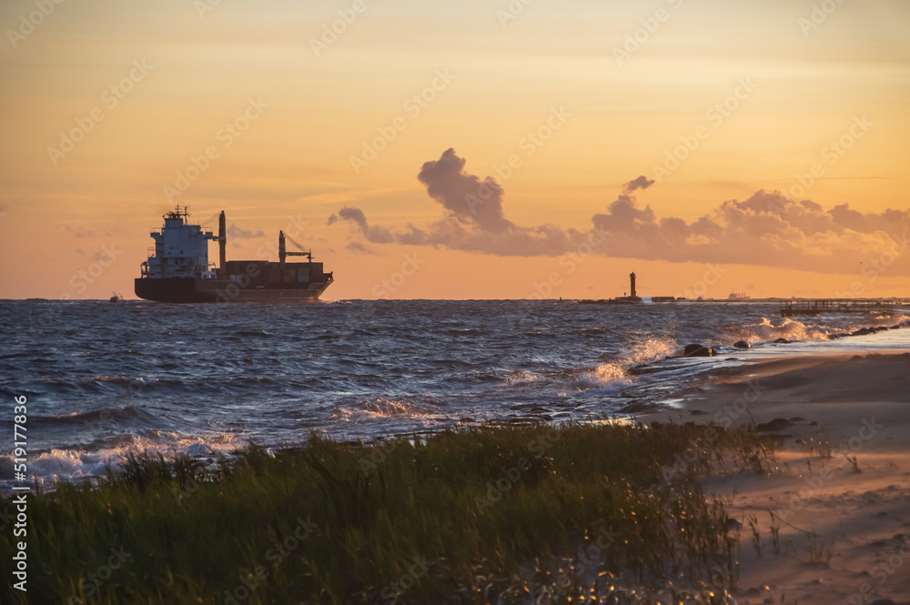 Fototapeta premium Ship leaving the harbor on sunny and clear sunny evening