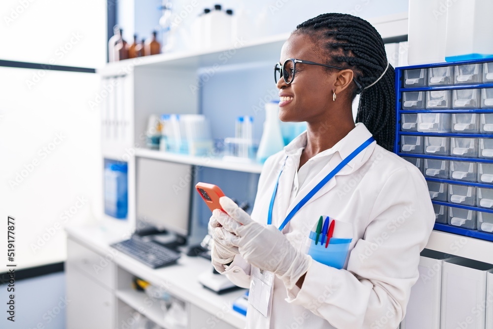 African american woman scientist smiling confident using smartphone at laboratory African american woman scientist smiling confident using smartphone at laboratory