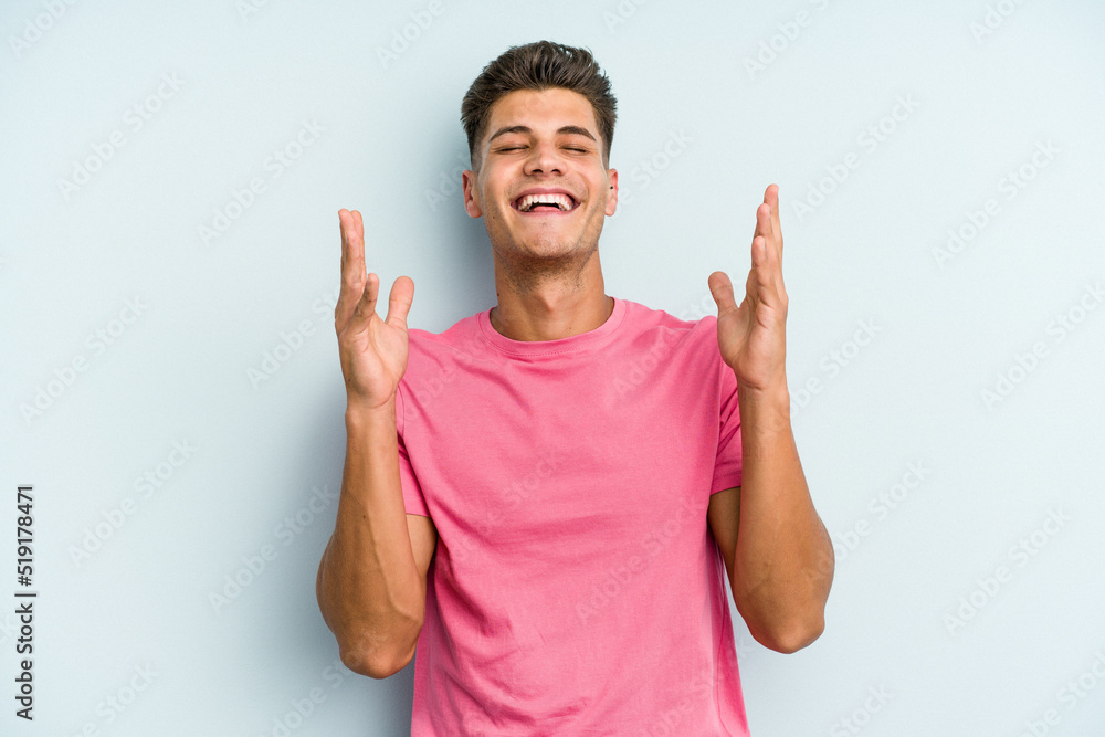 Young caucasian man isolated on blue background joyful laughing a lot. Happiness concept. Young caucasian man isolated on blue background joyful laughing a lot. Happiness concept.