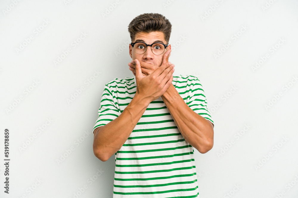 Young caucasian man isolated on white background shocked covering mouth with hands. Young caucasian man isolated on white background shocked covering mouth with hands.