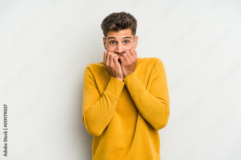 Fototapeta premium Young caucasian man isolated on white background biting fingernails, nervous and very anxious.