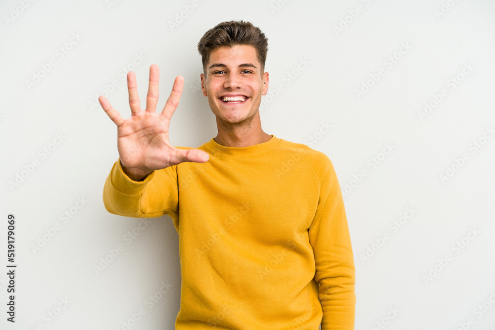 Young caucasian man isolated on white background smiling cheerful showing number five with fingers. Young caucasian man isolated on white background smiling cheerful showing number five with fingers.