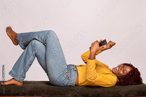 Εκτύπωση καμβά black lady lying on a bench using a phone rejoices