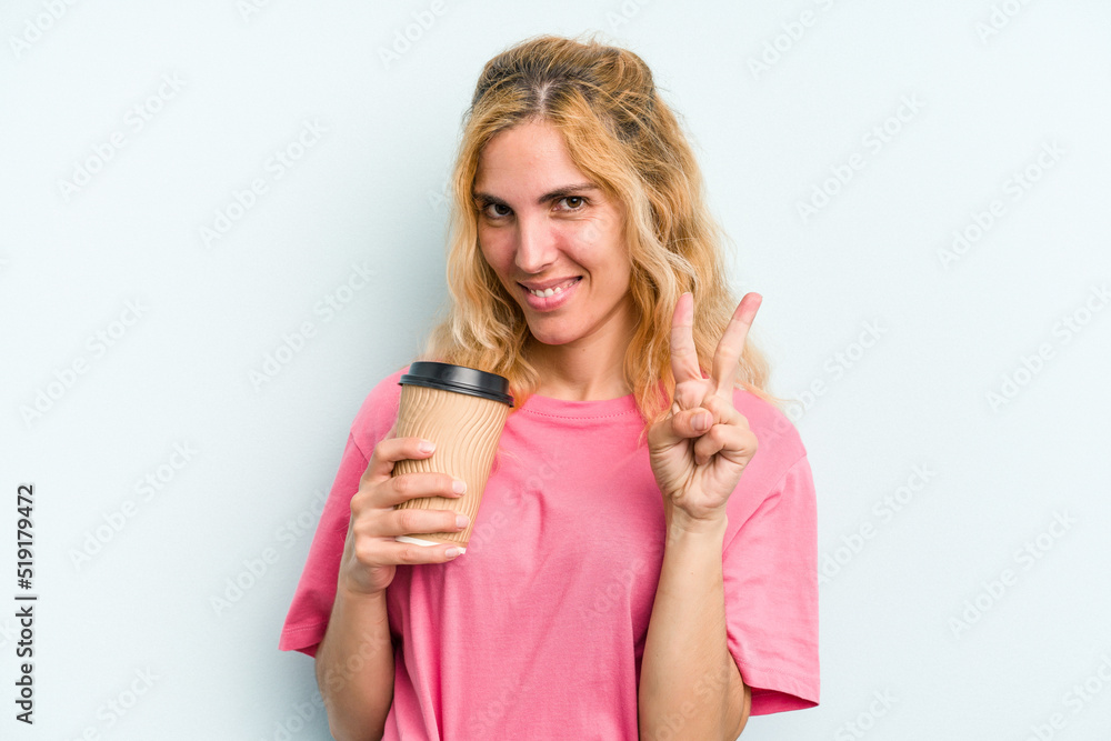 Young caucasian woman holding a take away coffee isolated on blue background showing number two with fingers. Young caucasian woman holding a take away coffee isolated on blue background showing number two with fingers.