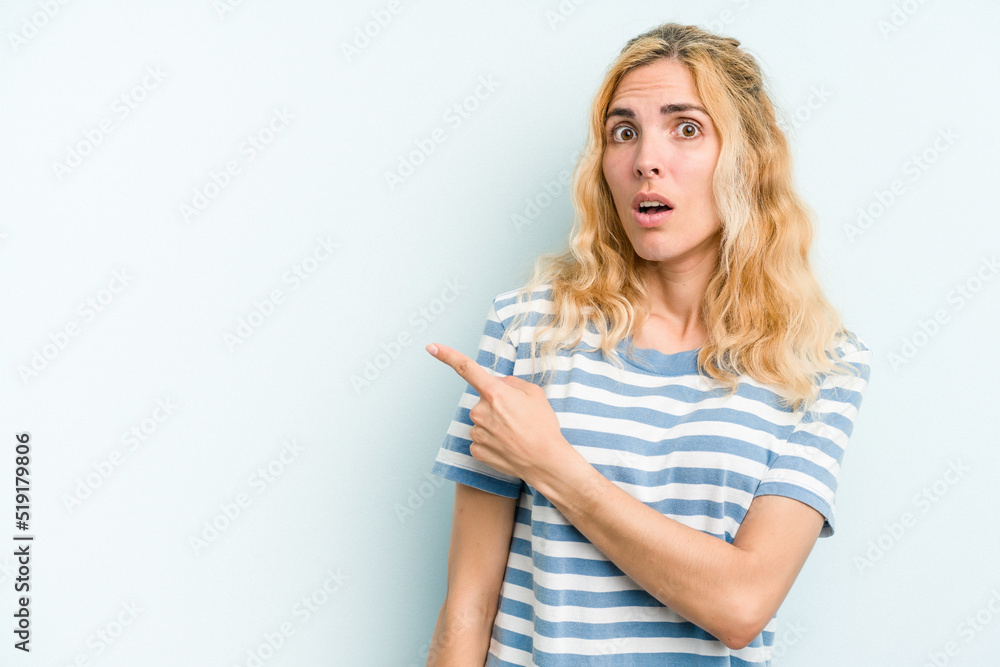 Young caucasian woman isolated on blue background pointing to the side Young caucasian woman isolated on blue background pointing to the side