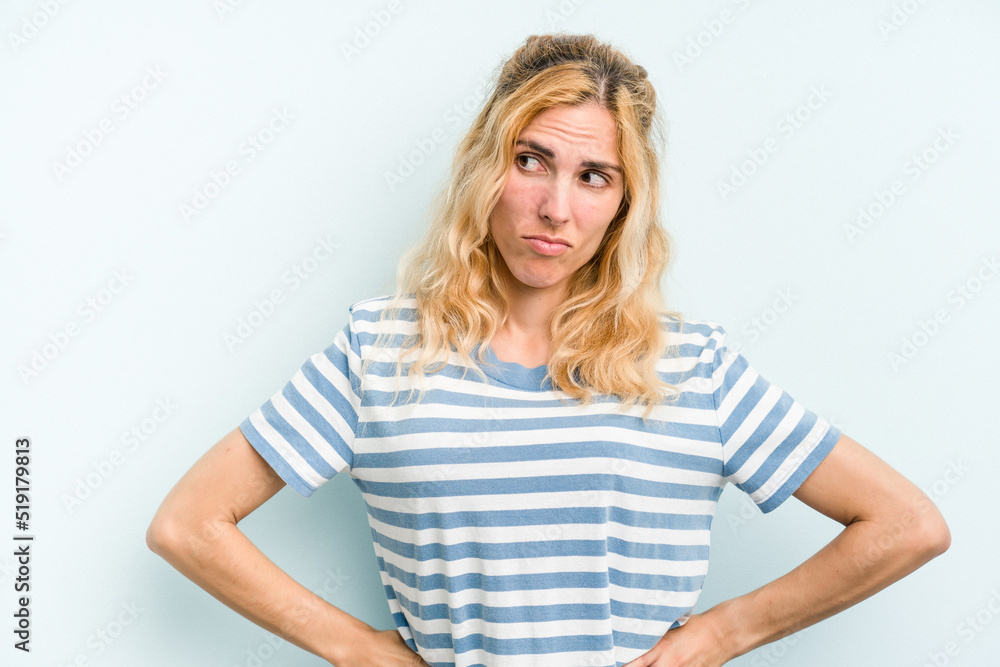 Young caucasian woman isolated on blue background confused, feels doubtful and unsure. Young caucasian woman isolated on blue background confused, feels doubtful and unsure.
