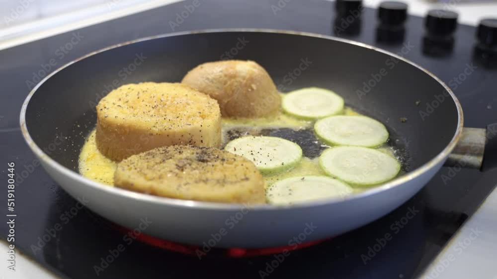 close-up in a black pan with a non-stick coating fried bread croutons and eggs with zucchini. Healthy breakfast. close-up in a black pan with a non-stick coating fried bread croutons and eggs with zucchini. Healthy breakfast.