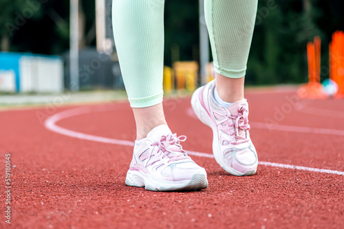Close-up, female legs in sneakers at the stadium.