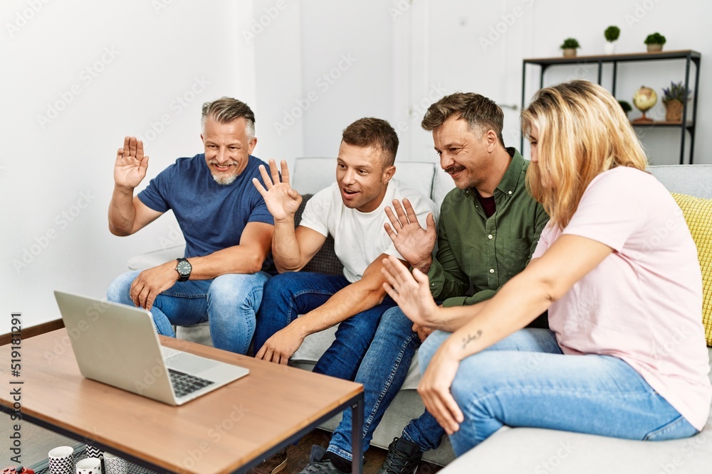 Group of middle age friends having video call using laptop sitting on the sofa at home. Group of middle age friends having video call using laptop sitting on the sofa at home.