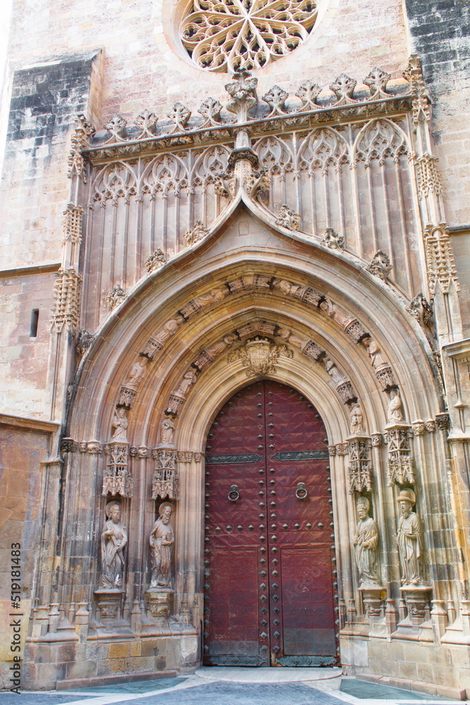 Spectacular gothic facade of Murcia Cathedral with sculptures, pointed arch and rose window
