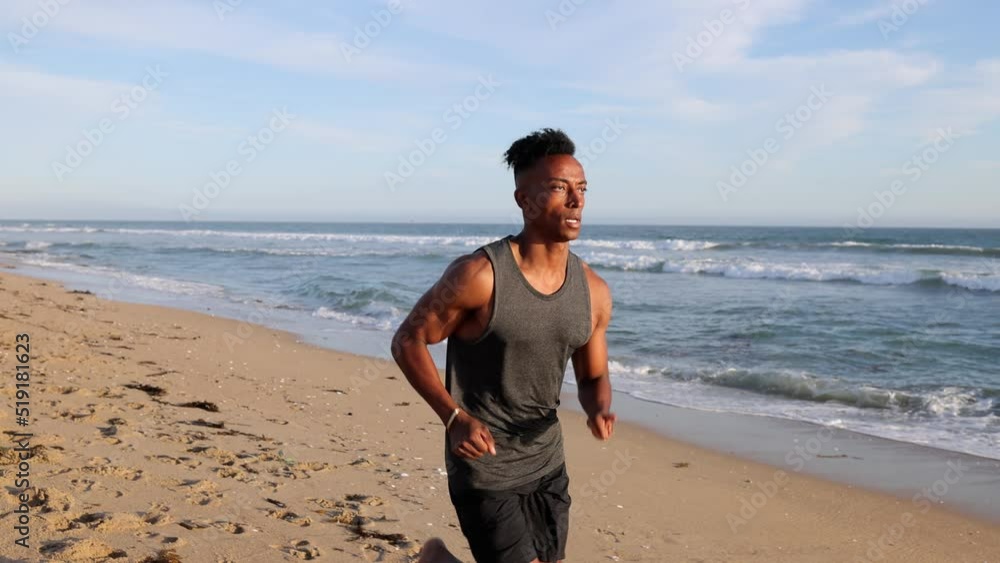 African American man working out by jogging at the beach in Southern California. Slow Motion. Jogger's left hand is deformed. African American man working out by jogging at the beach in Southern California. Slow Motion. Jogger's left hand is deformed.