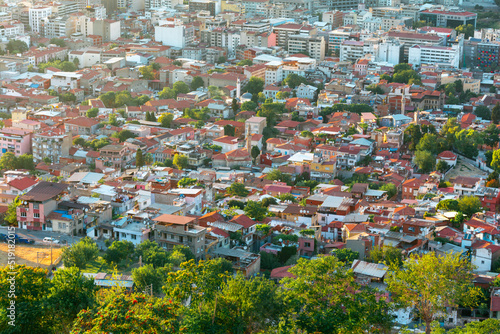 Landscape of Izmir city from high view at sunset with orange roofs and moody atmosphere.