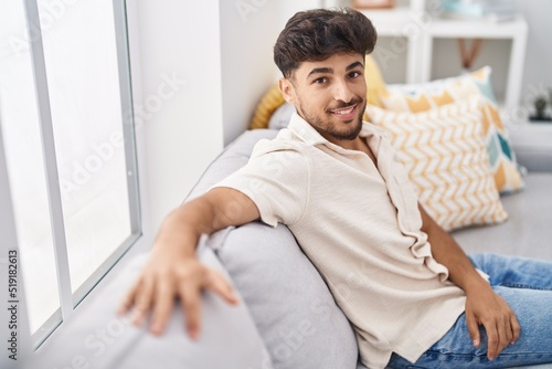 Free Download Young arab man smiling confident sitting on sofa at home - GFXLoad