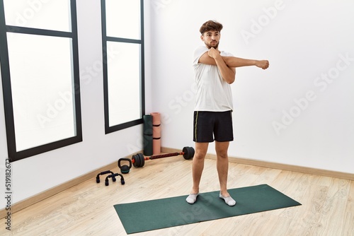 Young arab man stretching at sport center