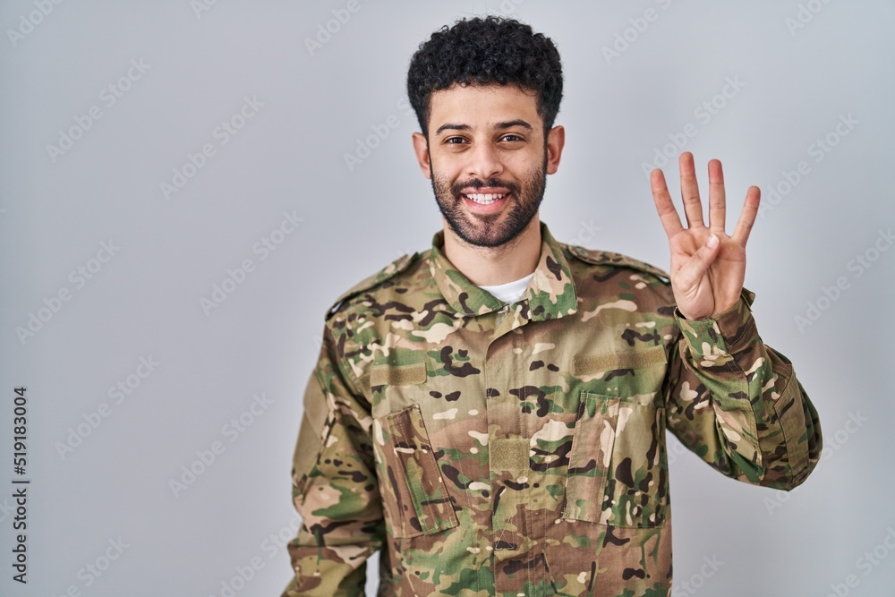 Arab man wearing camouflage army uniform showing and pointing up with fingers number four while smiling confident and happy. Arab man wearing camouflage army uniform showing and pointing up with fingers number four while smiling confident and happy.