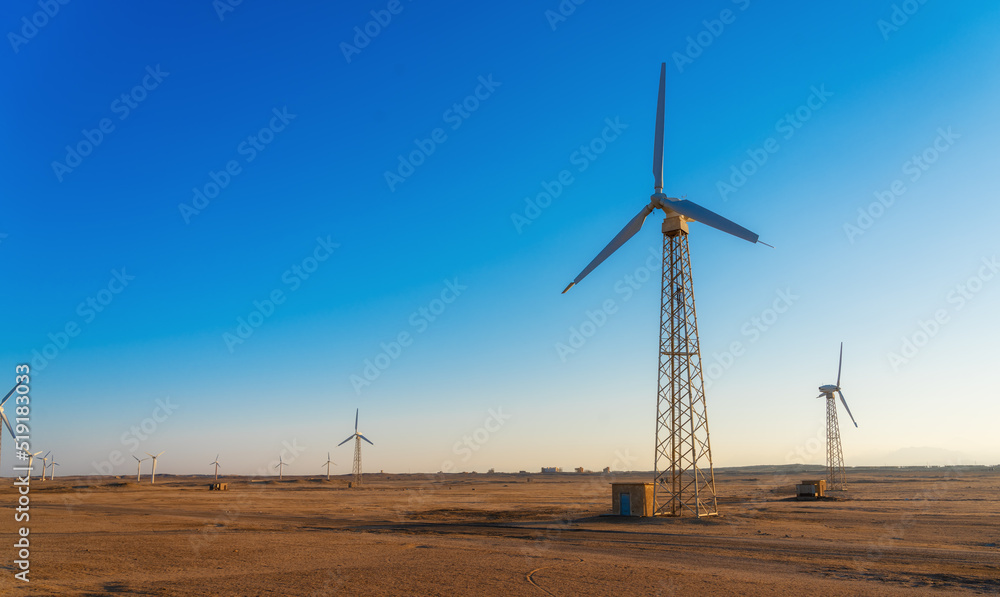 Wind power plants in desert at sunset Wind power plants in desert at sunset