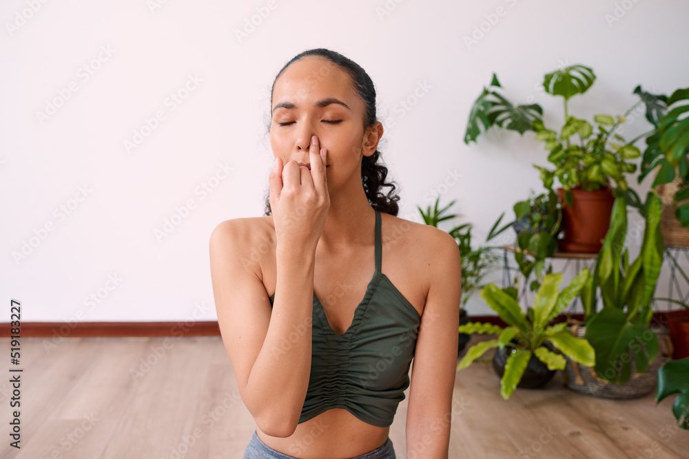 A young woman meditates with alternate nostril breathing to calm anxiety A young woman meditates with alternate nostril breathing to calm anxiety