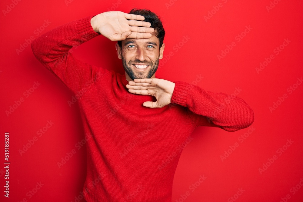 Handsome man with beard wearing casual red sweater smiling cheerful playing peek a boo with hands showing face. surprised and exited