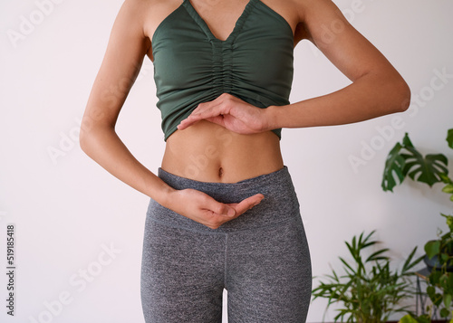 Cropped shot of a young multi-ethnic woman's stomach cupped by her hands photo