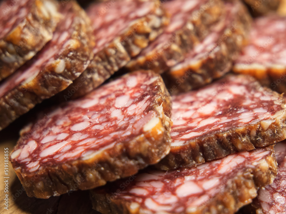 Delicious meat appetizer. Chunks of dried sausage taken in macro.