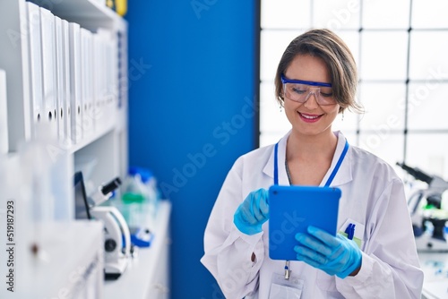Young woman scientist using touchpad at laboratory