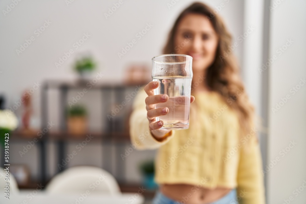 Young woman drinking glass of water standing at home Young woman drinking glass of water standing at home