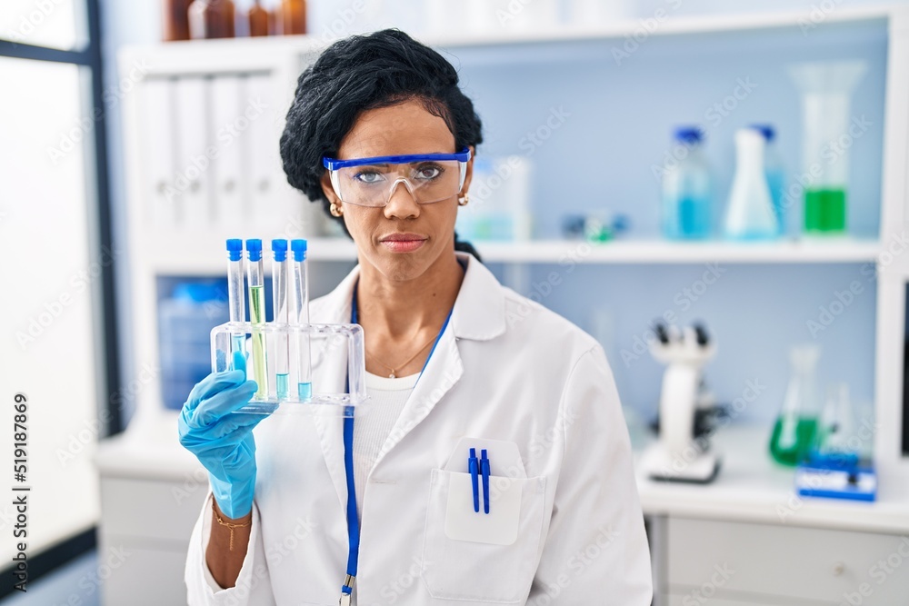 Middle age hispanic woman working at scientist laboratory thinking attitude and sober expression looking self confident Middle age hispanic woman working at scientist laboratory thinking attitude and sober expression looking self confident