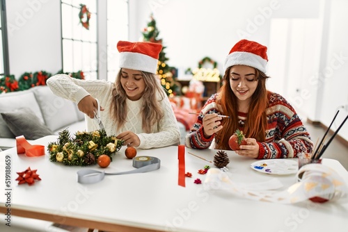 Woman couple making handmade christmas decoration sitting on the table at home