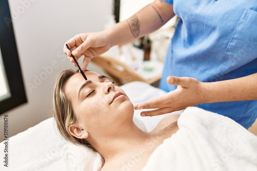 Woman couple having eyebrows treatment at beauty center photo