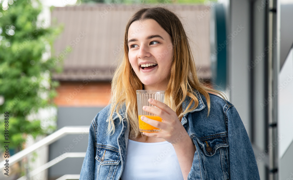 Woman drinks orange juice in a cafe, close-up. Woman drinks orange juice in a cafe, close-up.