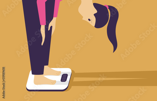 Woman stands on body scales - weight loss