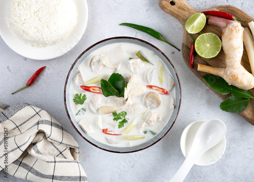 Soup Tom Kha Gai with chicken, lemongrass, kaffir, chili, lime and jasmine rice on a gray background, top view. Traditional Thai soup with coconut milk. Thai food, top view. photo