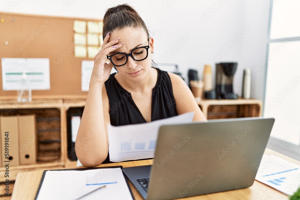 Young hispanic businesswoman overworked at the office. Young hispanic businesswoman overworked at the office.