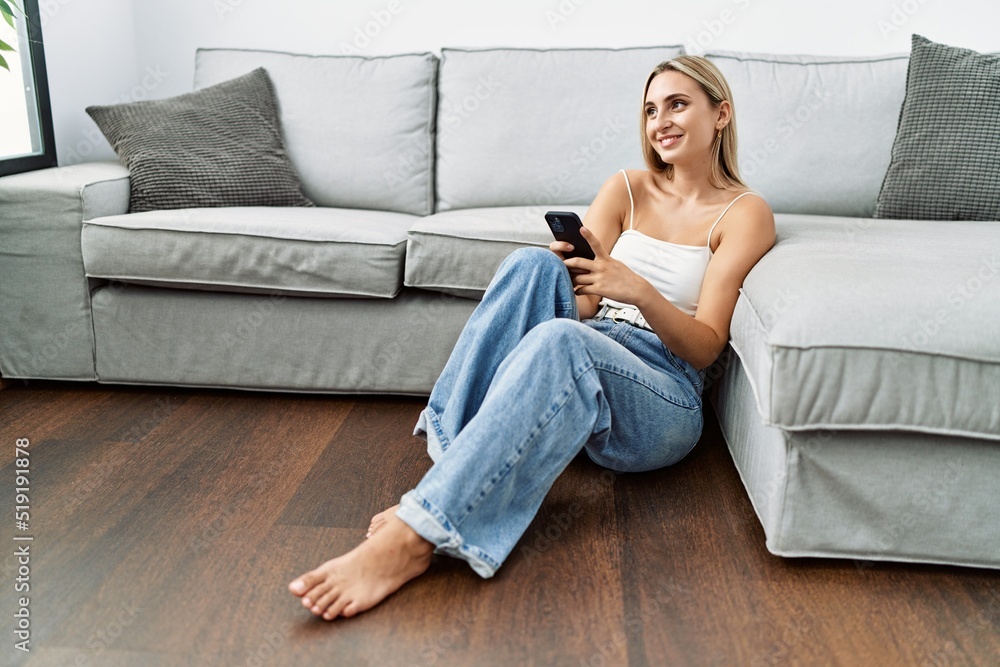 Obraz premium Young blonde woman smiling confident using smartphone at home