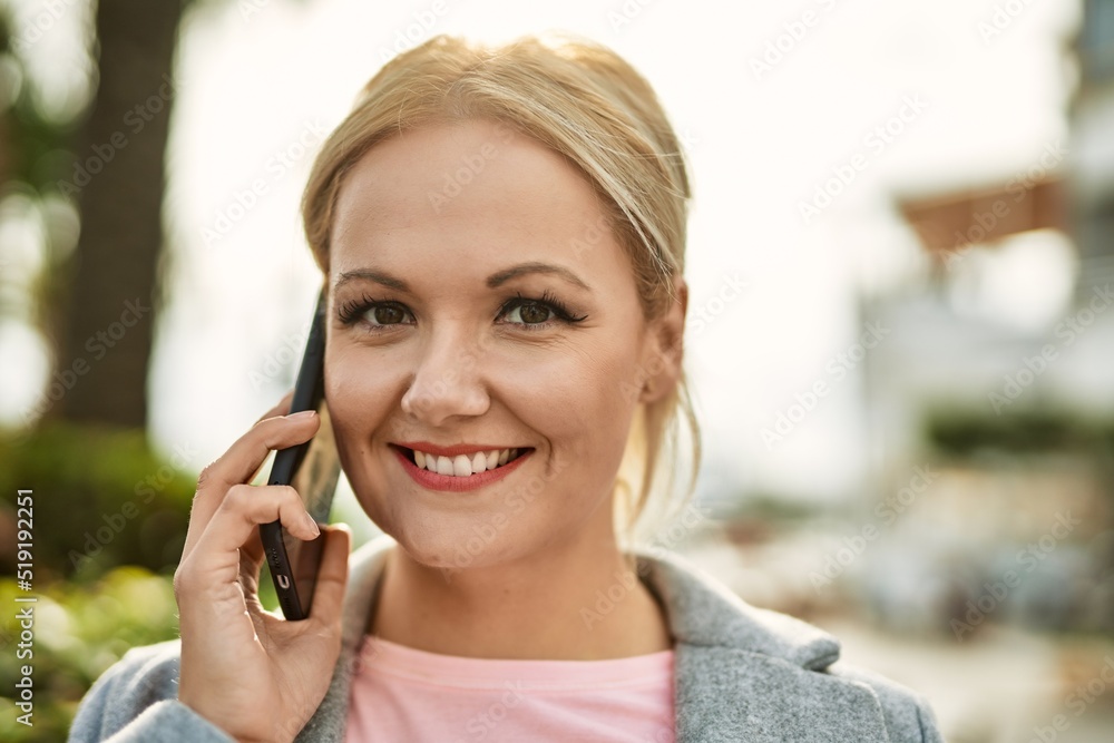 Young blonde businesswoman smiling happy talking on the smartphone at the city. Young blonde businesswoman smiling happy talking on the smartphone at the city.