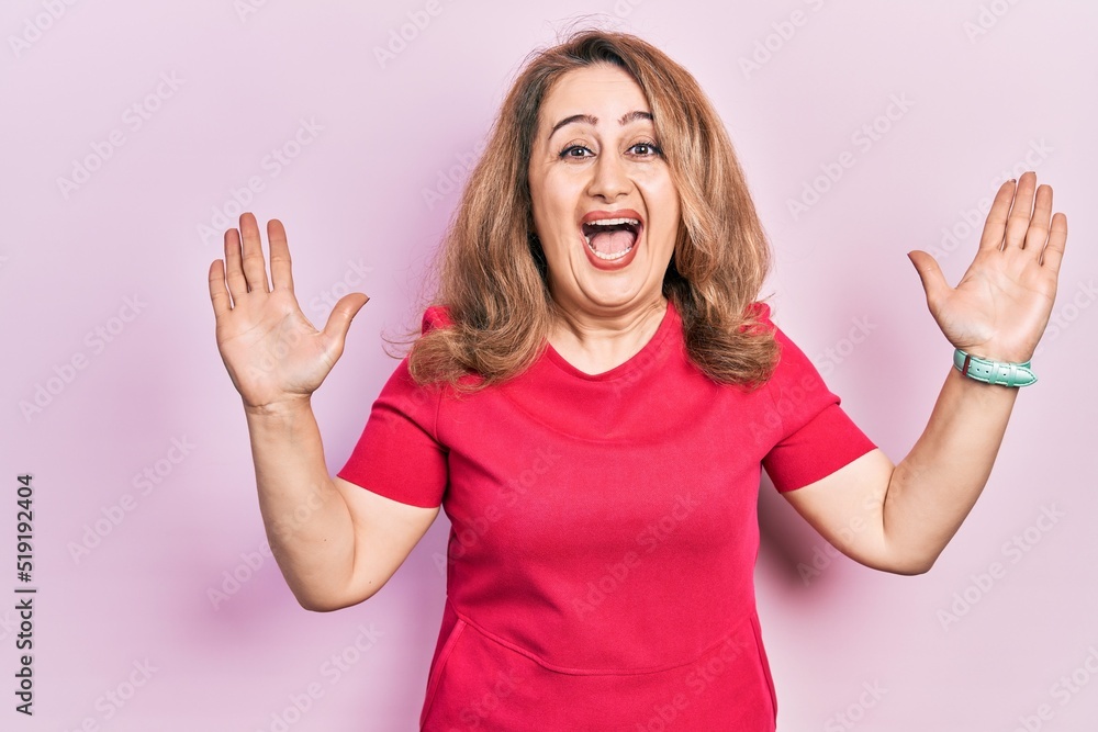 Middle age caucasian woman wearing casual clothes celebrating crazy and amazed for success with arms raised and open eyes screaming excited. winner concept Middle age caucasian woman wearing casual clothes celebrating crazy and amazed for success with arms raised and open eyes screaming excited. winner concept