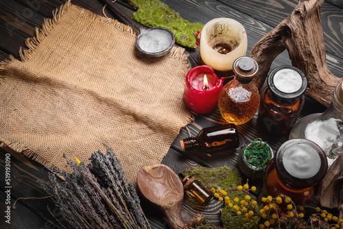 Herbal medicine concept background. Dry natural ingredients and remedy bottle on the wooden table background. Top view.
