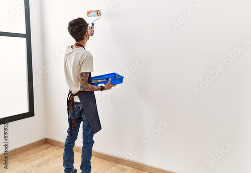 Painter painting wall using roller at home. photo
