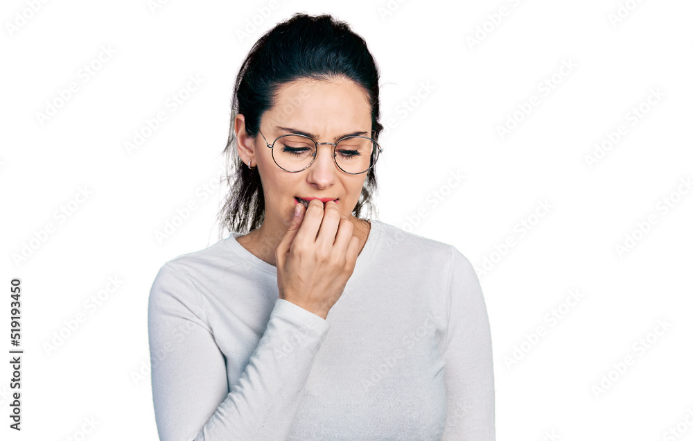 Young hispanic woman wearing casual clothes looking stressed and nervous with hands on mouth biting nails. anxiety problem. Young hispanic woman wearing casual clothes looking stressed and nervous with hands on mouth biting nails. anxiety problem.