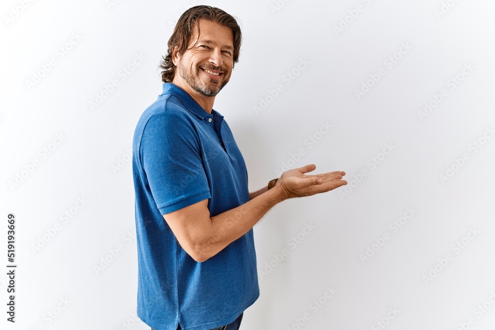 Handsome middle age man standing together over isolated background pointing aside with hands open palms showing copy space, presenting advertisement smiling excited happy Handsome middle age man standing together over isolated background pointing aside with hands open palms showing copy space, presenting advertisement smiling excited happy