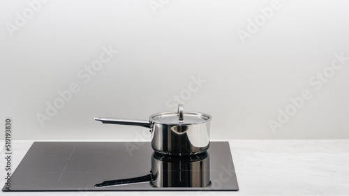 Saucepan on a glass-ceramic induction stove hob photo