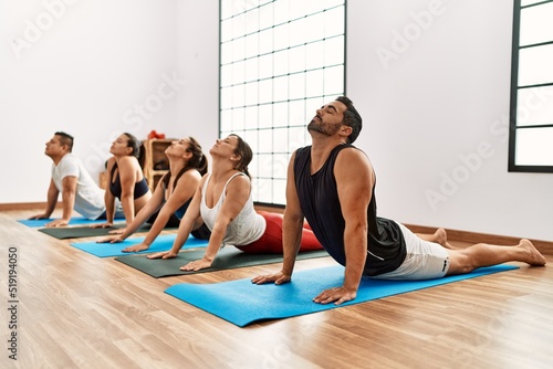 Group of young people concentrate stretching at sport center.