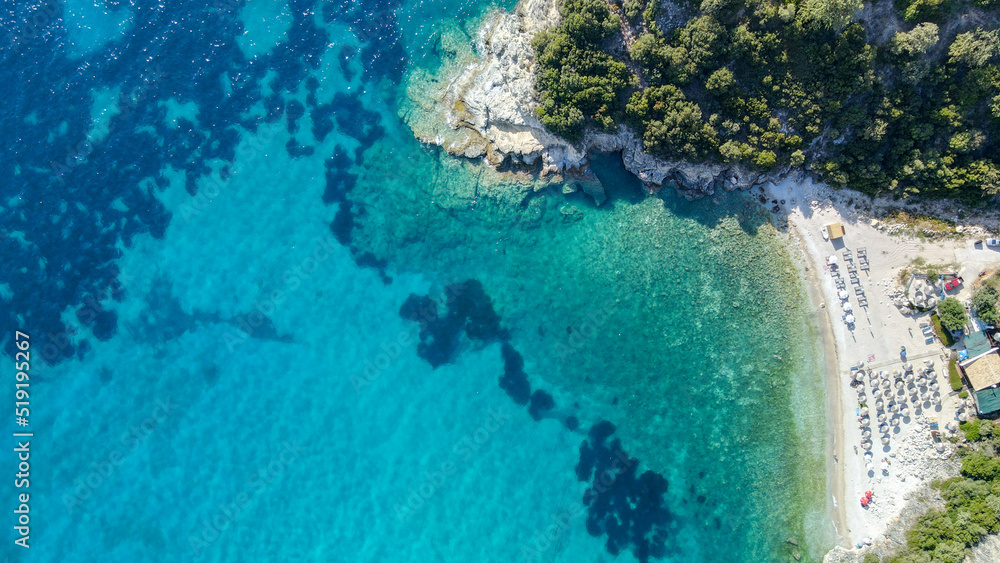 View from above, aerial view of an emerald and transparent Mediterranean sea with a white beach full of colored beach umbrellas and tourists who relax and swim View from above, aerial view of an emerald and transparent Mediterranean sea with a white beach full of colored beach umbrellas and tourists who relax and swim