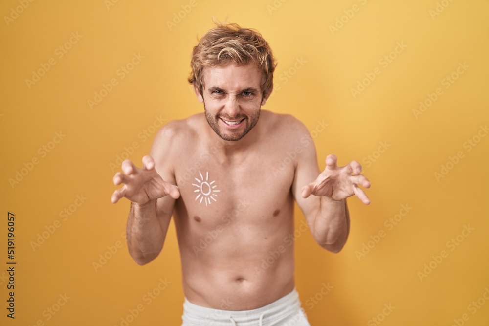 Caucasian man standing shirtless wearing sun screen smiling funny doing claw gesture as cat, aggressive and sexy expression